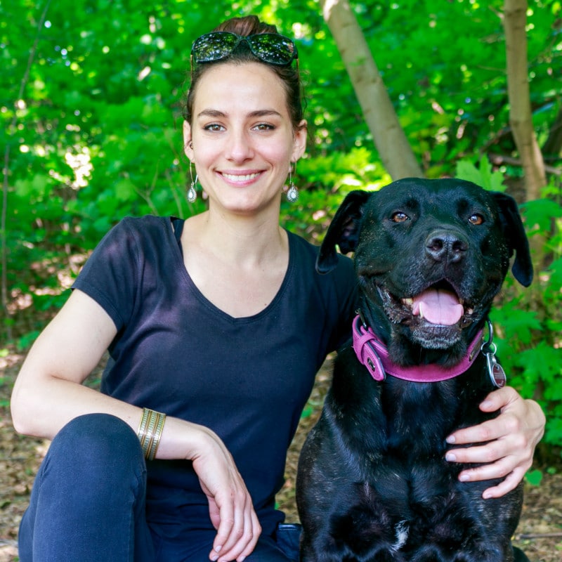 Jeune femme assise à côté d'un chien noir