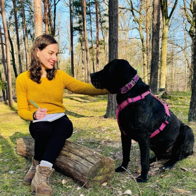 Jeune femme assise près d'un chien dans la forêt