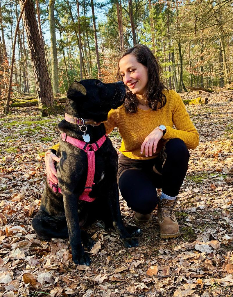 Jeune femme accroupie à côté d'un chien Jeune femme accroupie à côté d'un chien